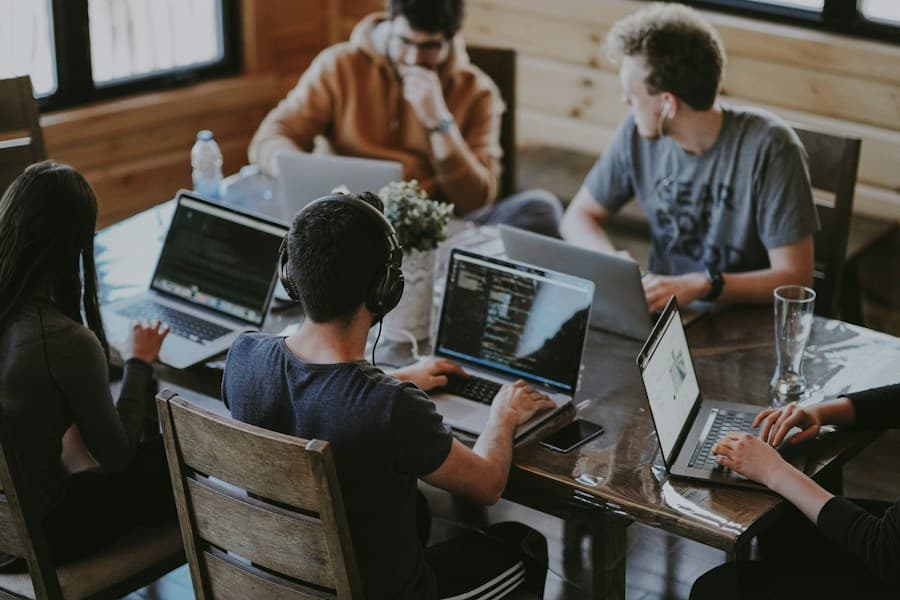 A team collaborating around laptops in a shared studio